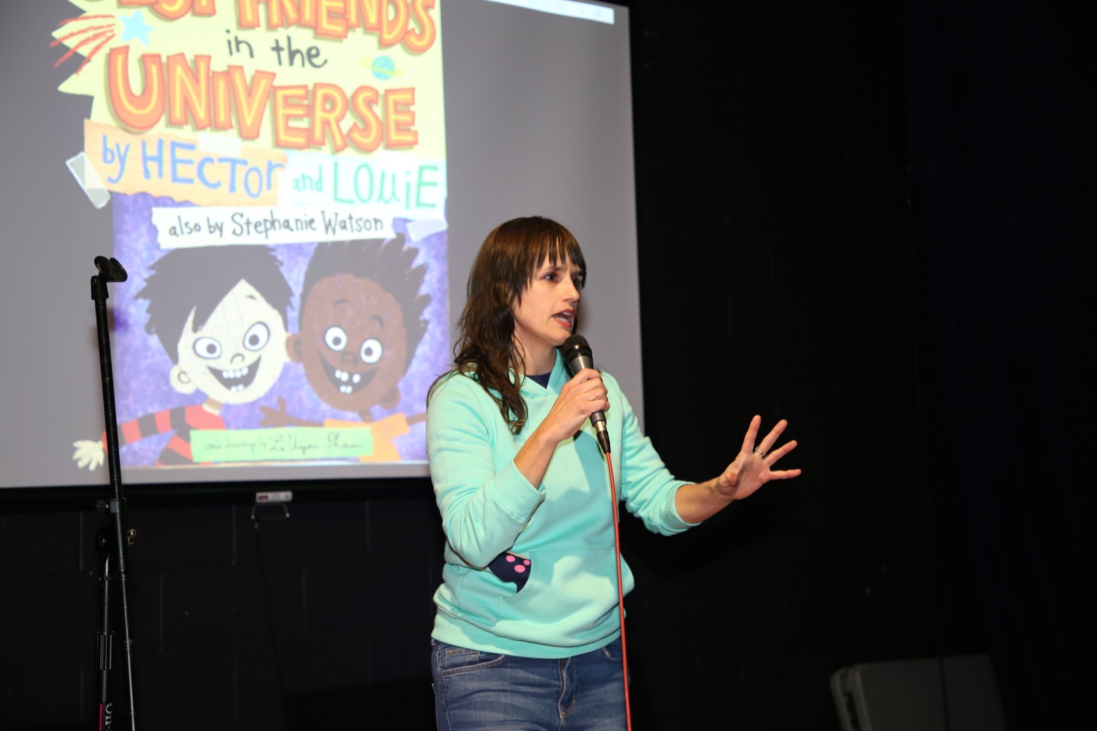 Stephanie Watson speaking on stage with a microphone